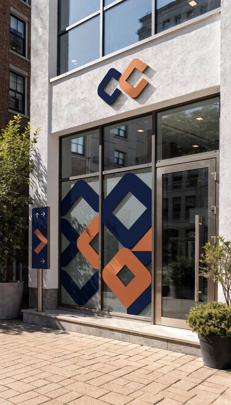 A modern small office building facade photographed from street level showing a cohesive layered signage system, featuring a prominent dimensional logo sign mounted on clean white walls, frosted window decals with geometric brand patterns on large glass windows, a sleek wayfinding directional sign near the entrance, and subtle pavement graphics leading to the glass front door, all using a consistent navy blue and copper color scheme, professional commercial photography, bright natural daylight, sharp architectural details, welcoming entrance with potted plants flanking the doorway, contemporary minimalist design aesthetic, ultra-high resolution